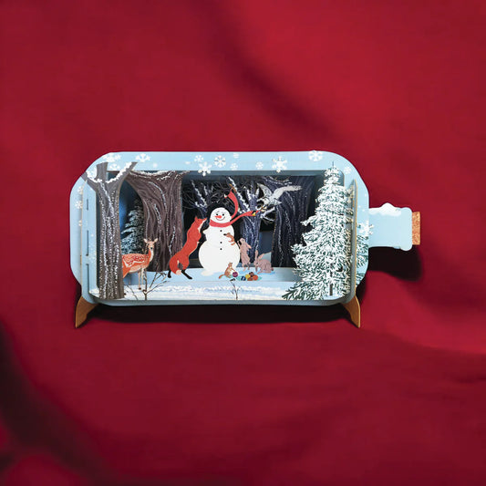 Snowman pop-up Christmas card with red scarf, woodland animals, snowy forest, and presents in a magical 3D festive scene.