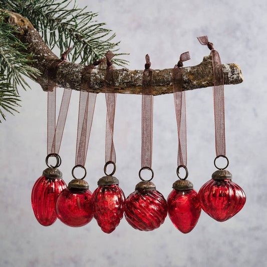 A set of 6 small red crackle glass baubles with ornate caps and organza ties, hanging from a wooden branch.