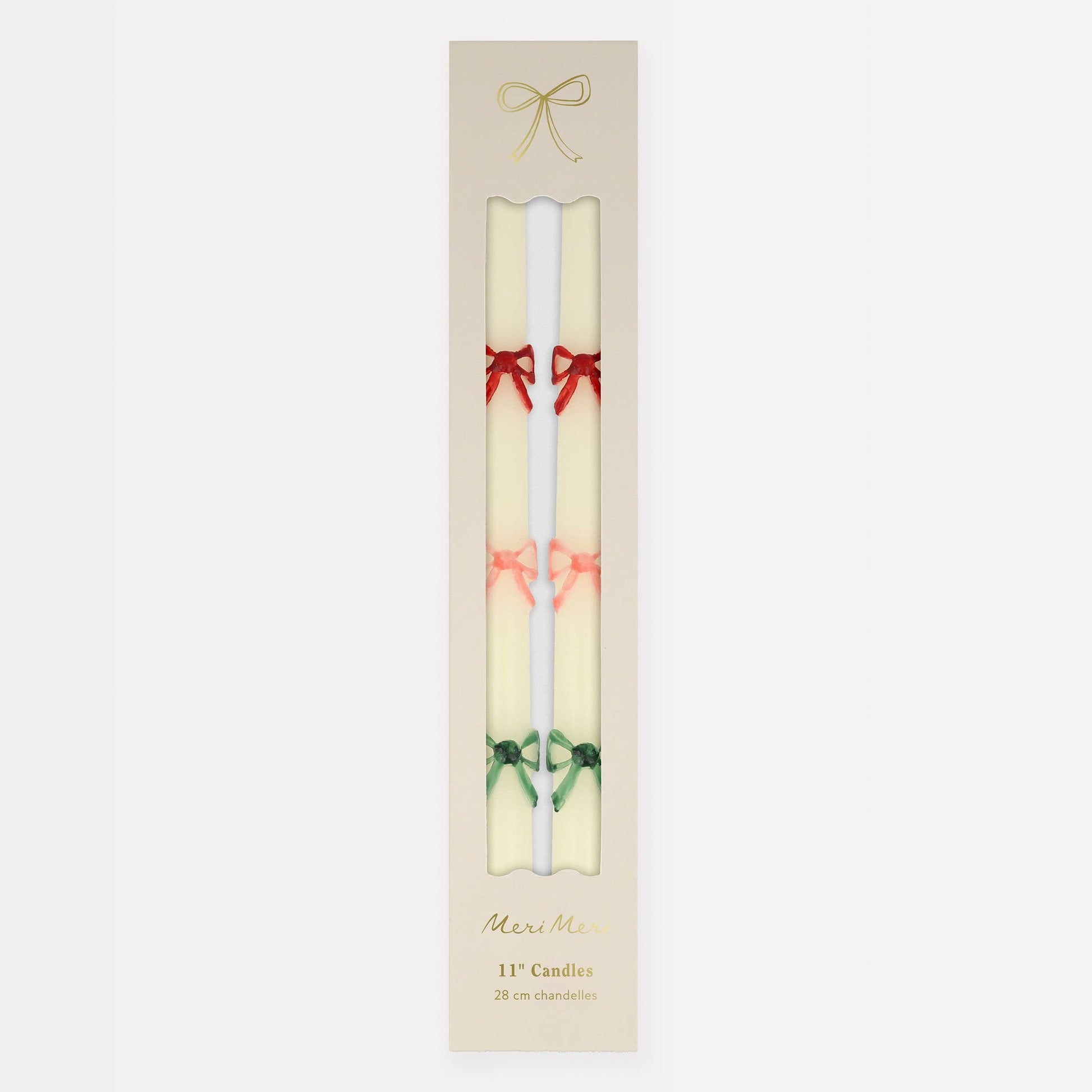 Two candles with decorative bows in a beige packaging on a white background