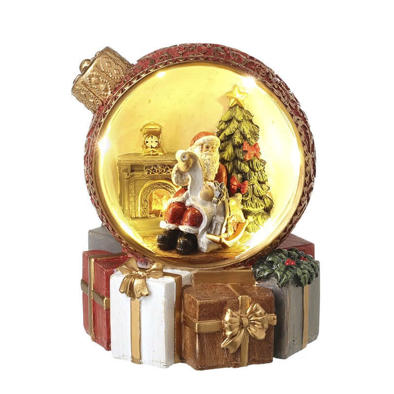Decorative Christmas ornament with Santa Claus, reindeer, and tree inside a glowing ball.