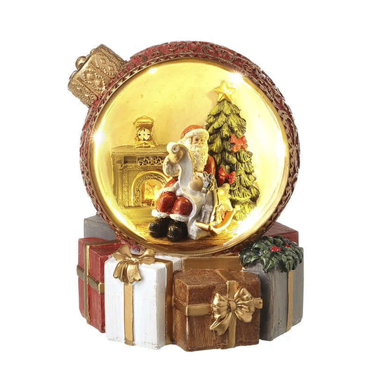 Decorative Christmas ornament with Santa Claus, reindeer, and tree inside a glowing ball.
