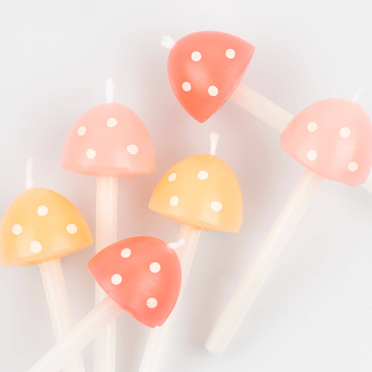 Set of colorful mushroom-shaped candles on a white background