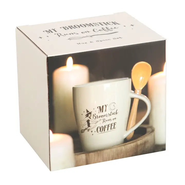 Mug and candle set with 'My Broomstick Runs on Coffee' text in packaging