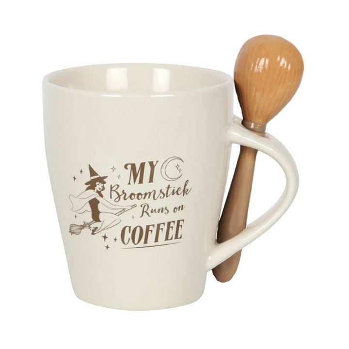 White mug with broomstick spoon featuring a humorous coffee-themed design on a white background