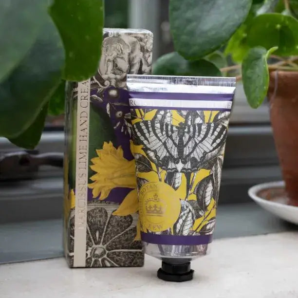 Hand cream with decorative packaging and a box on a surface with plants in the background