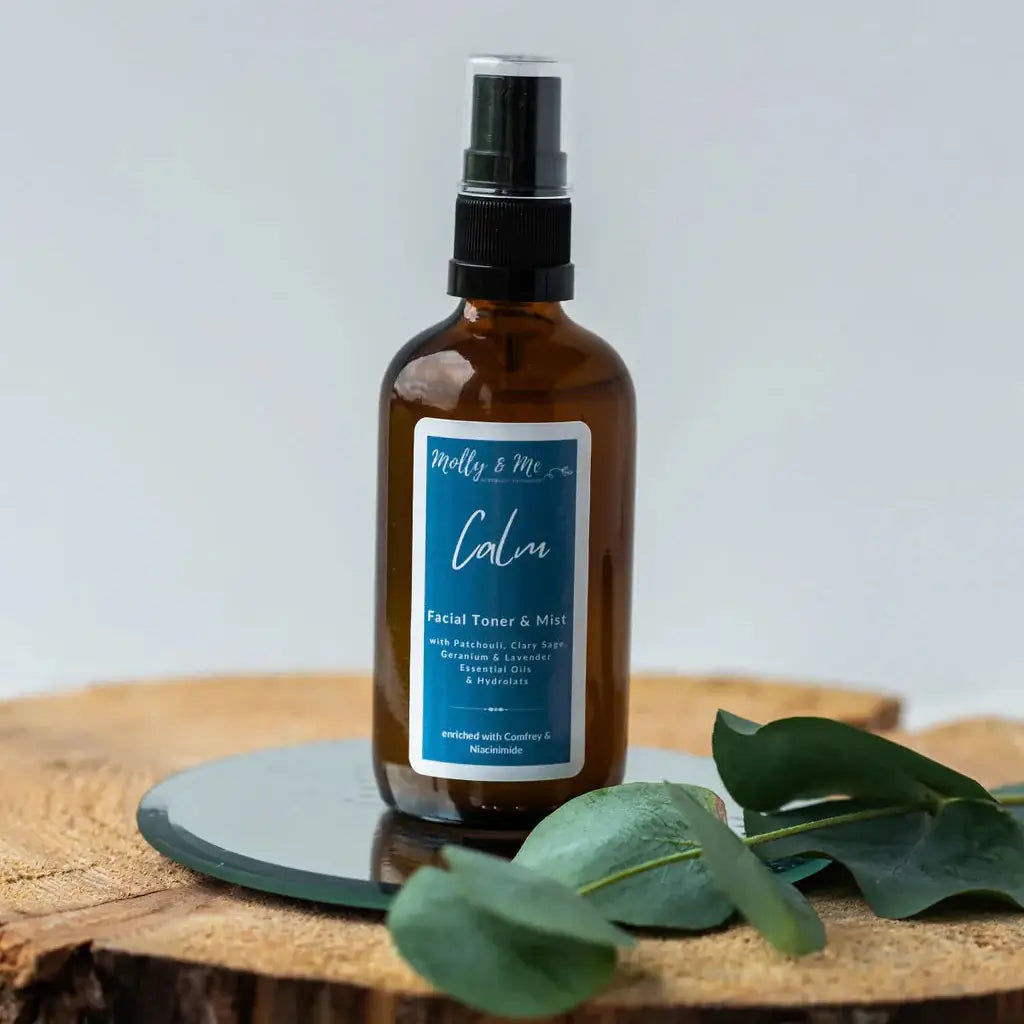 Brown bottle with a label on a wooden surface with green leaves