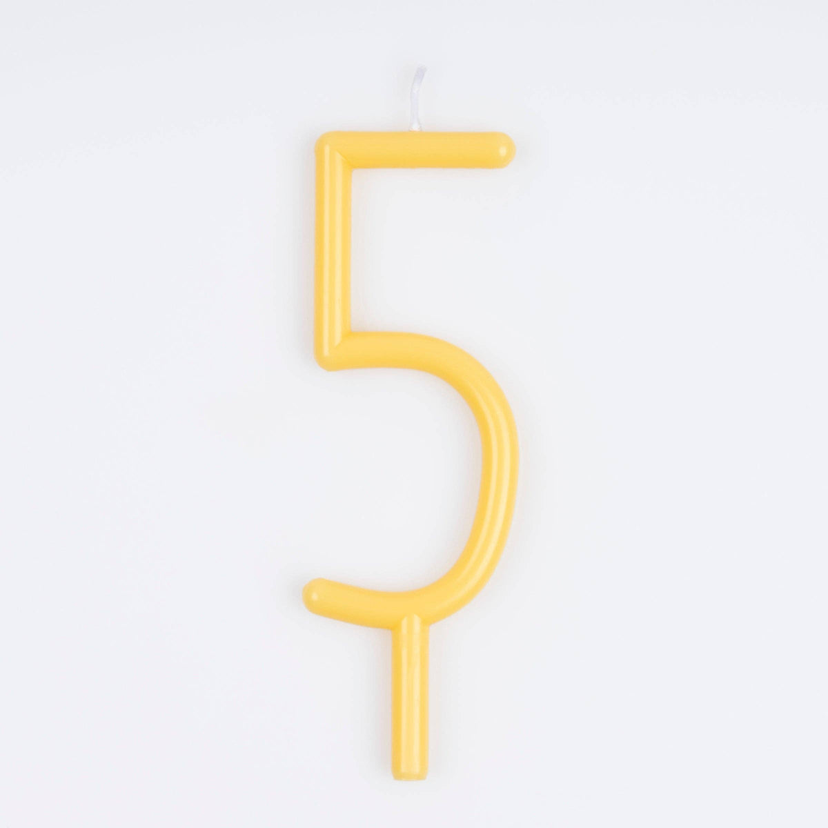 A yellow candle shaped like the number five, shown against a plain white background.