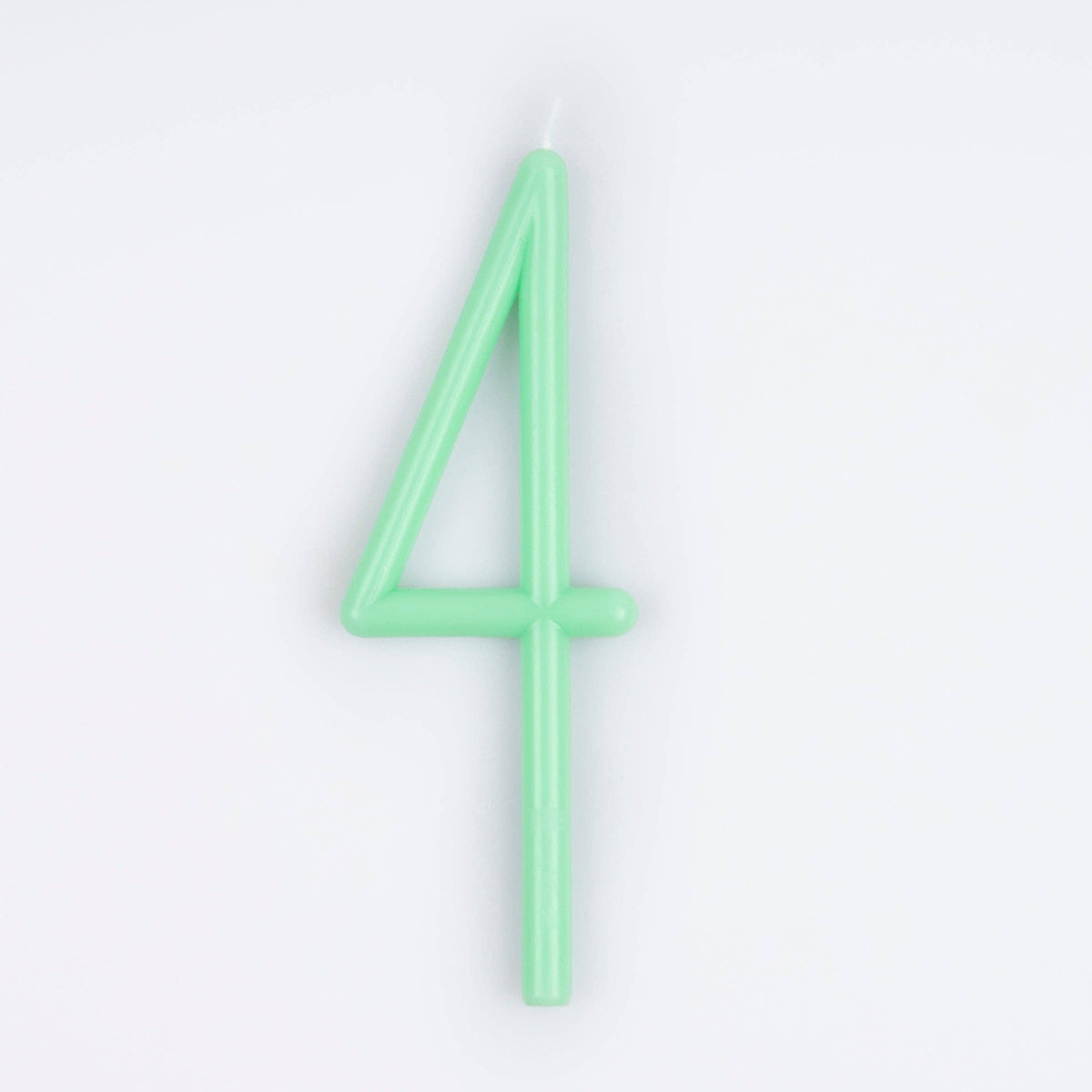 A mint green candle shaped like the number 4, photographed on a clean white background.