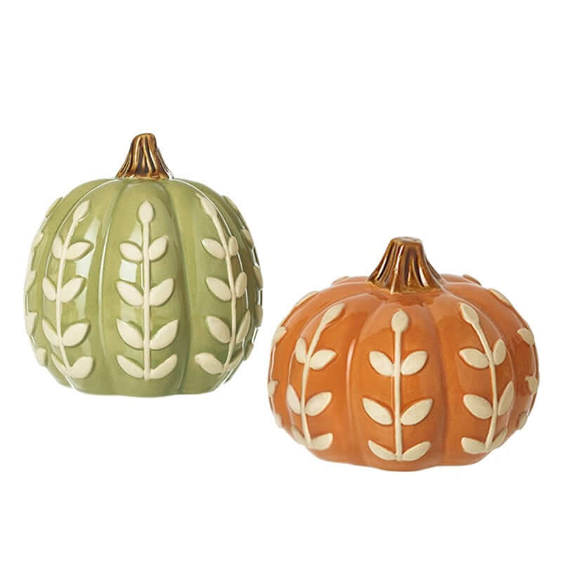 Two ceramic pumpkins, one green and one orange, with leaf patterns on a white background.