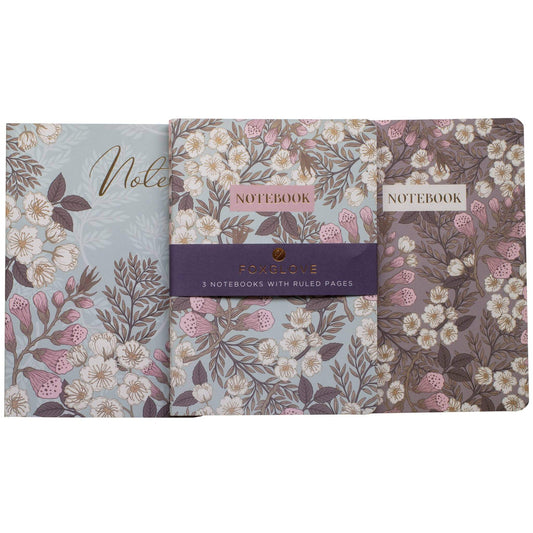 Set of three floral notebooks with visible branding on a white background