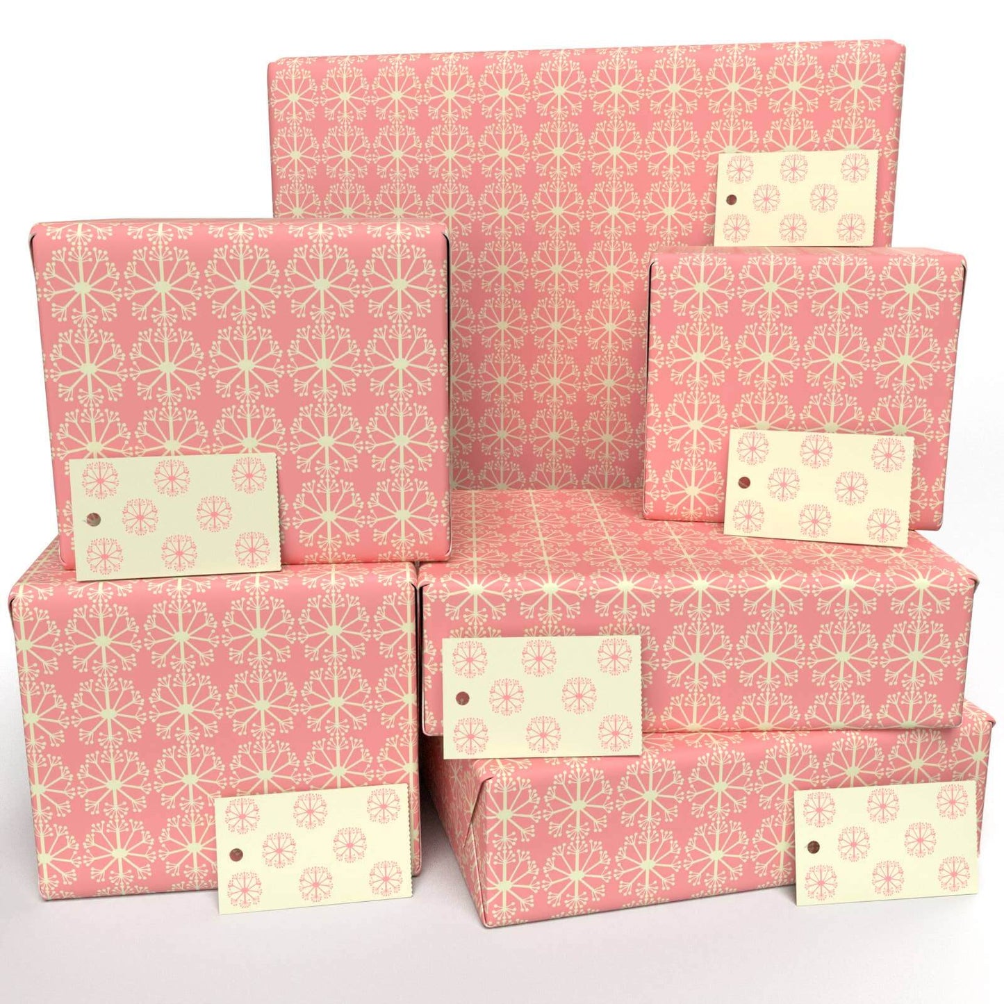 Stacks of pink wrapping paper with a dotted pattern, featuring a design that is biodegradable and compostable, made with vegetable-based inks.