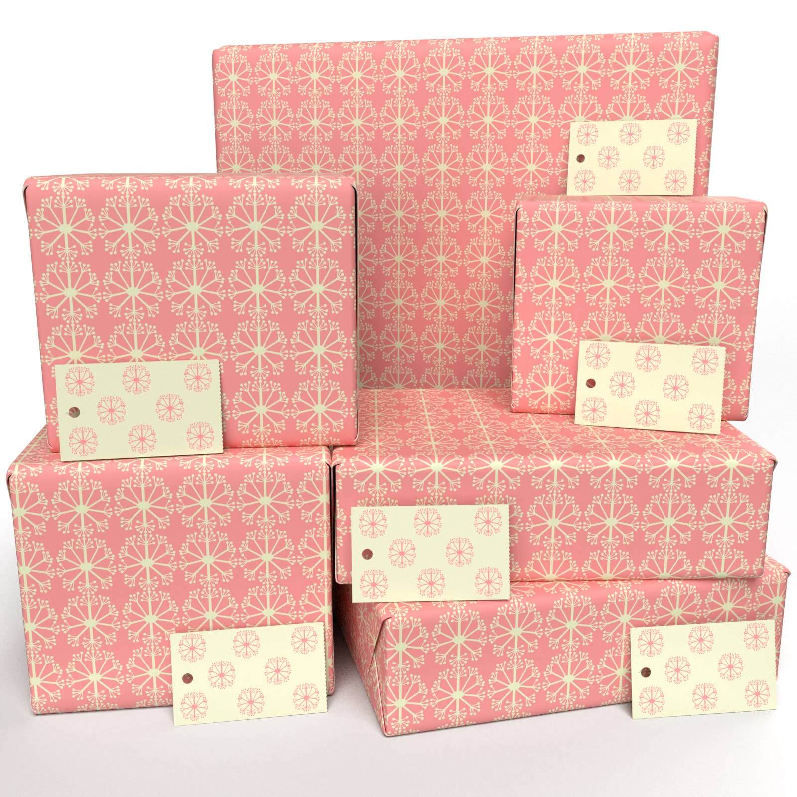 Stacks of pink wrapping paper with a dotted pattern, featuring a design that is biodegradable and compostable, made with vegetable-based inks.