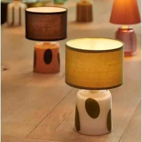 Decorative table lamps with polka dot bases on a wooden floor.