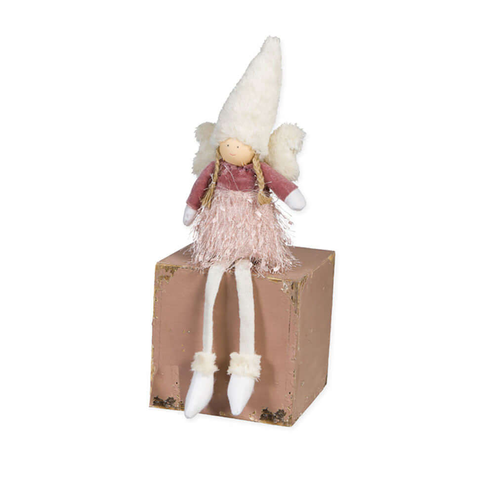 Cute plush pink angel decoration sitting on a box on a white background