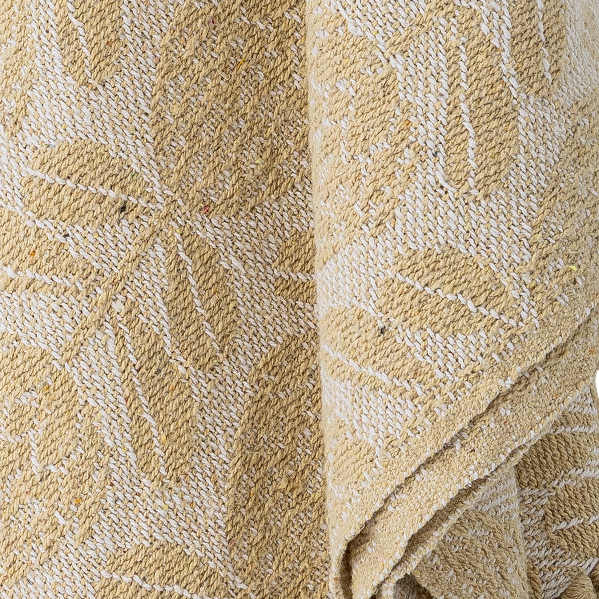 Cream blanket draped over a textured chair with a decorative fan on the wall.