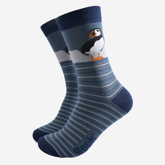 Pair of socks with a penguin design on a light gray background