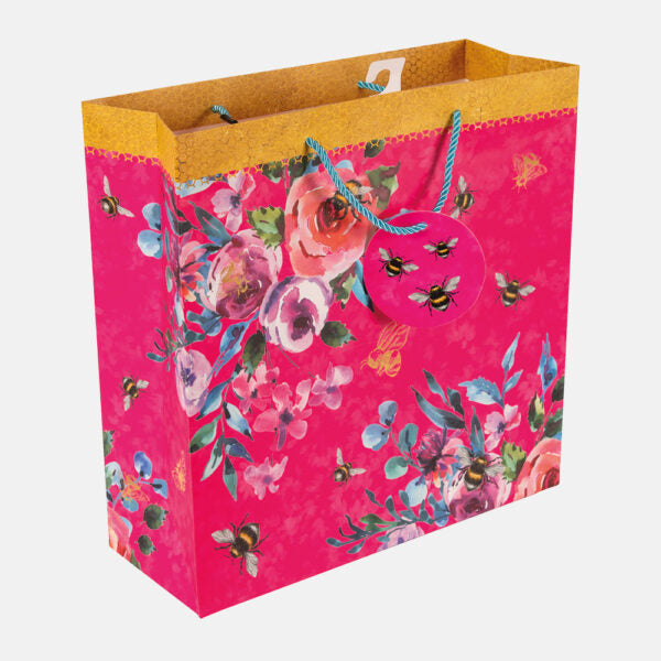 Floral-patterned gift bag with pink background and yellow top edge on a white background