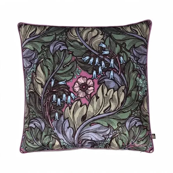 A square decorative throw pillow featuring an intricate Art Nouveau floral and leaf pattern in muted green, lavender, beige, and pink, with a small black brand tag on the bottom right edge.