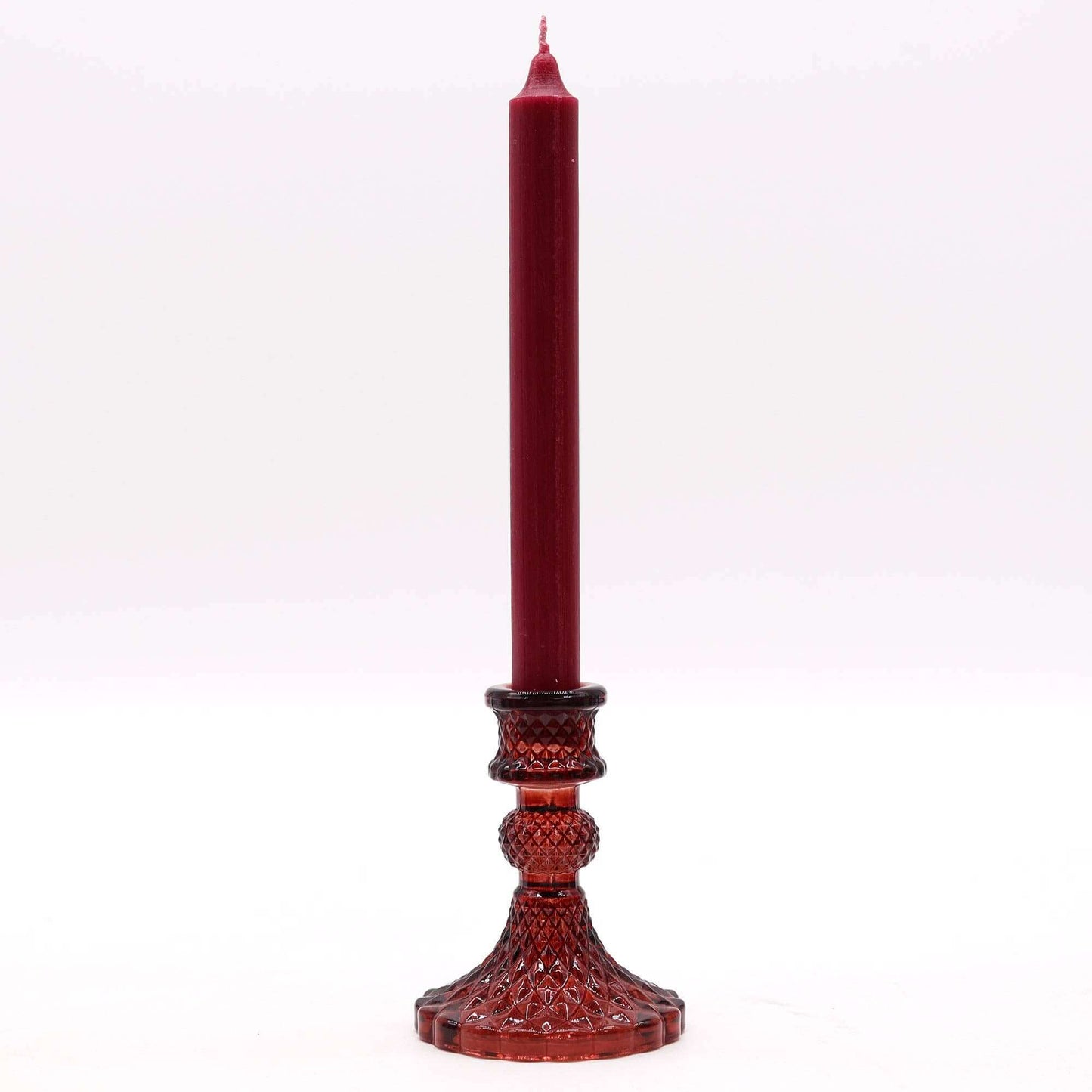 Red candle on a decorative candlestick against a white background