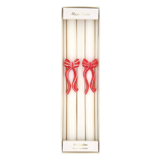 Set of two candles with red bows in a decorative box on a white background