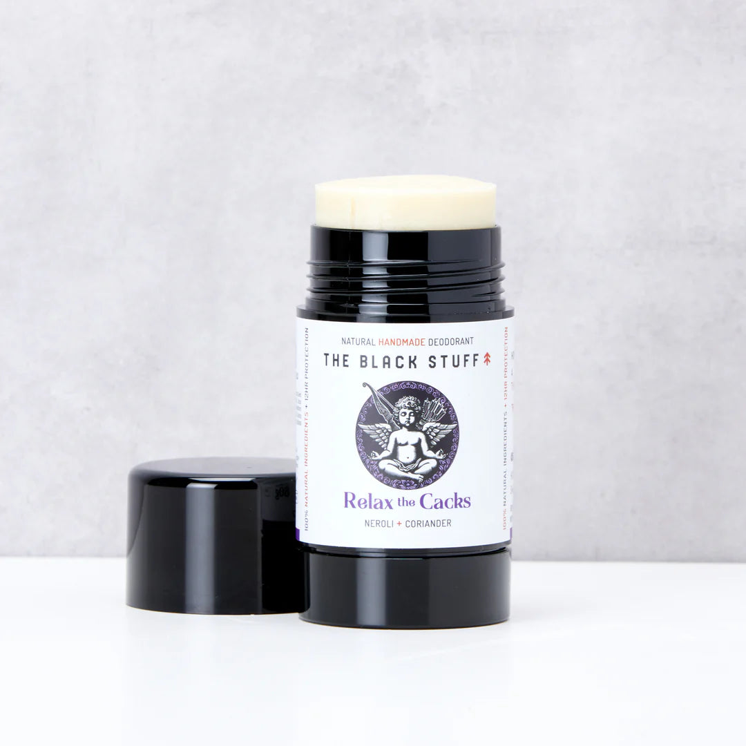Deodorant stick with 'The Black Stuff' packaging on a light gray background