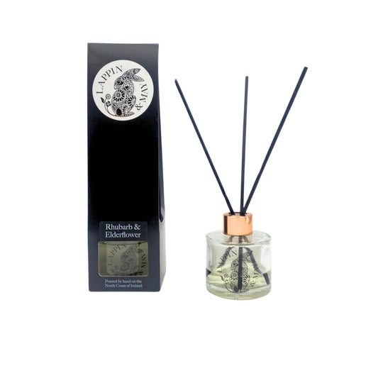 A Reed diffuser with black reeds in a clear glass bottle, with a black box packaging that has the brand name 'Lappin & May' and the product name 'Rhubarb & Elderflower' on it.