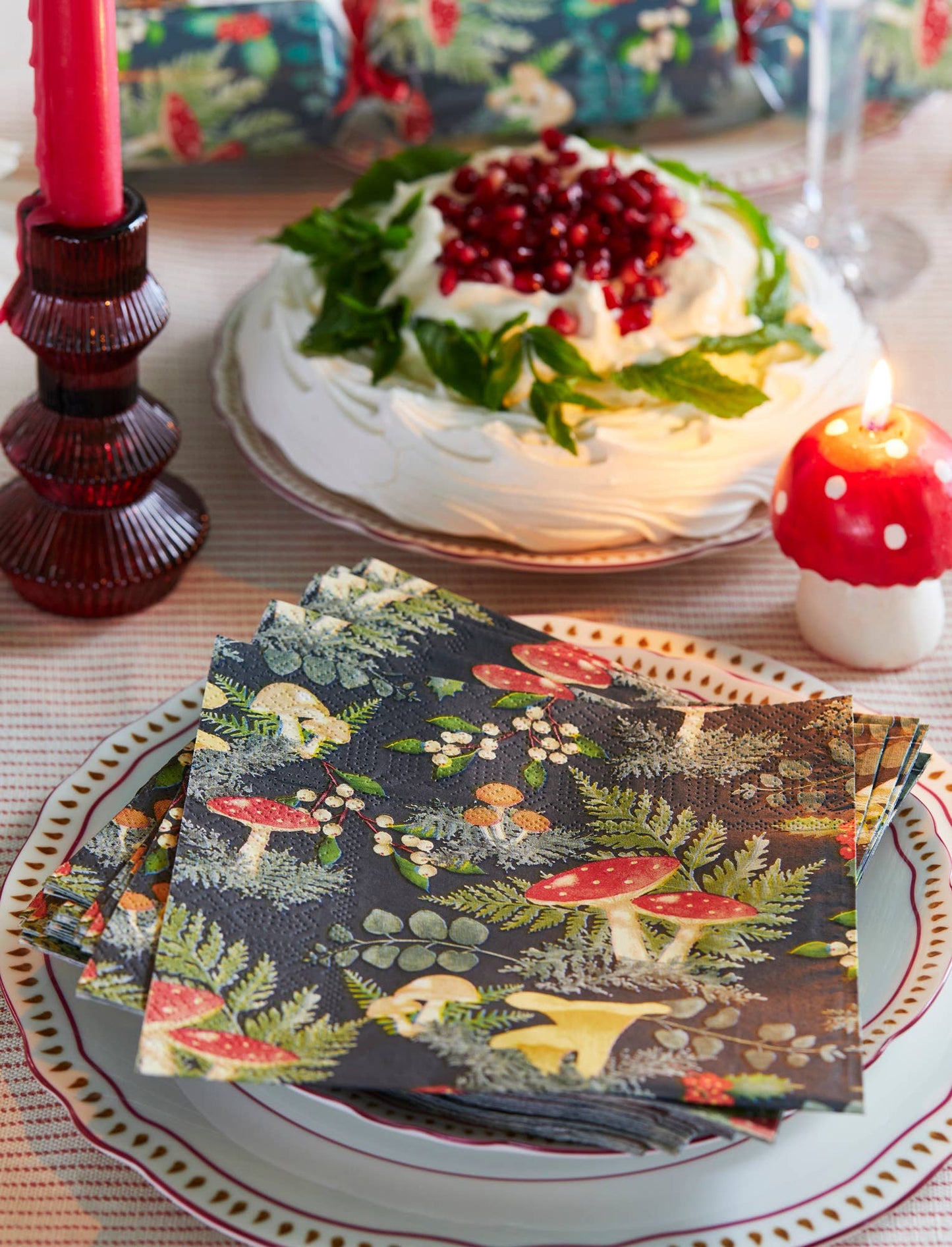 Napkins with a forest design on a table with a cake and candles.