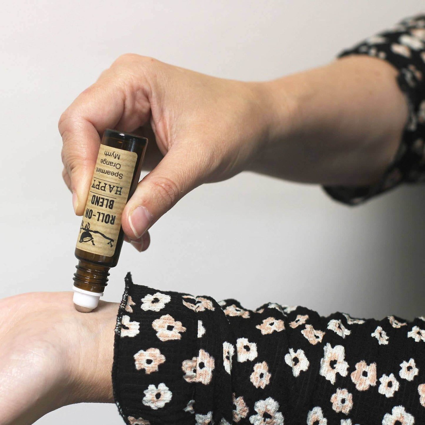 Image of a lady using the roll on essential oil on her wrist