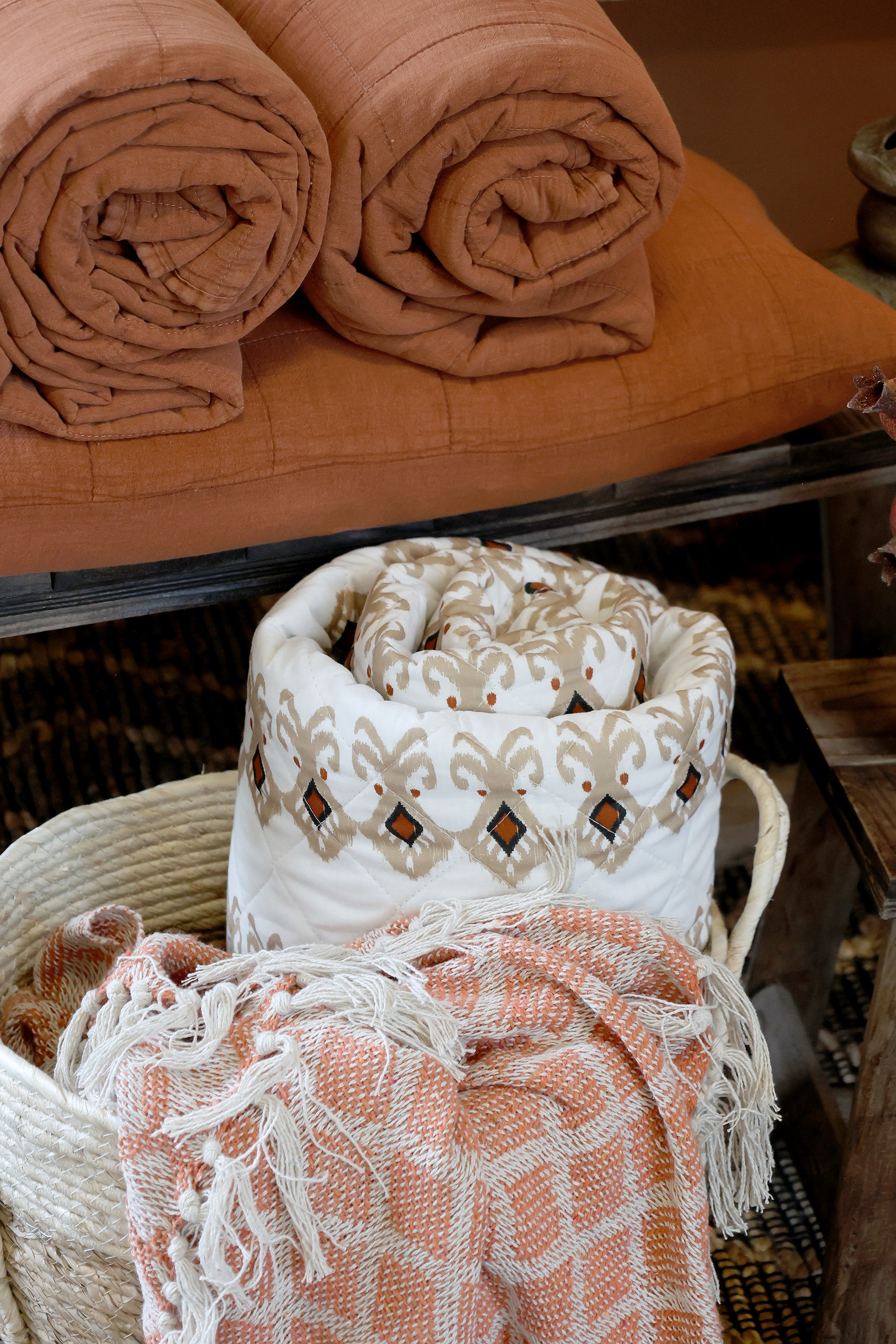 Folded and textured towels in various patterns and colors on a wooden surface.