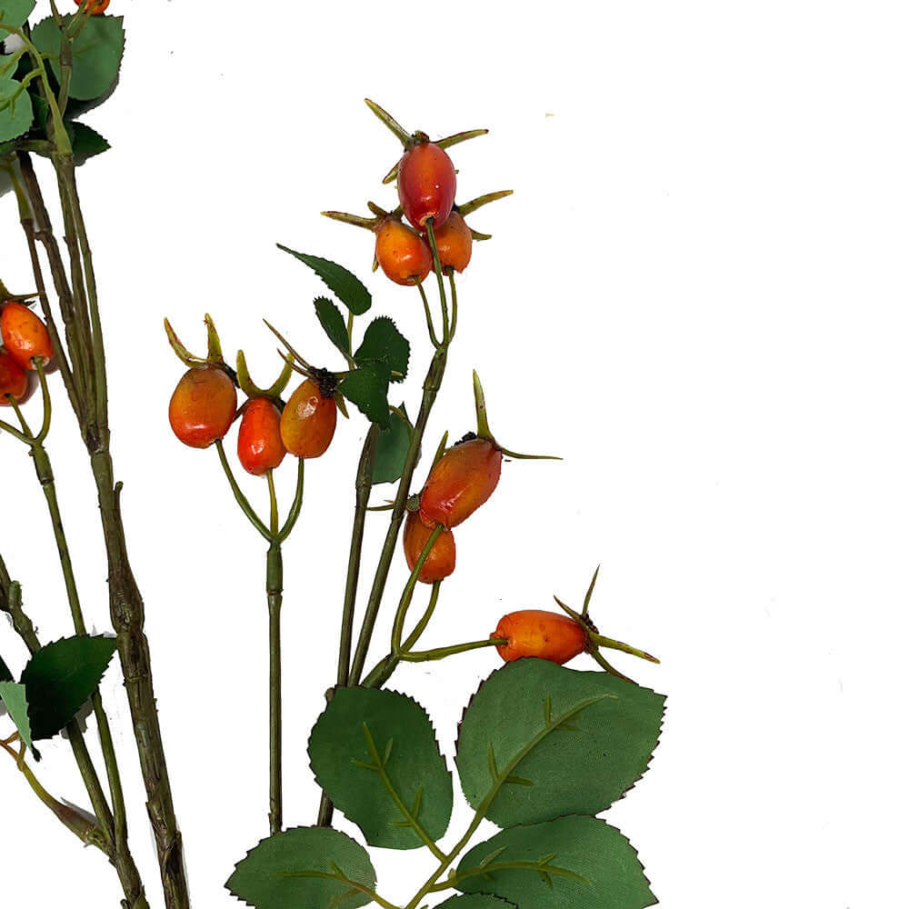 Artificial rosehip branch with green textured leaves and clusters of orange-red berries on a white background.