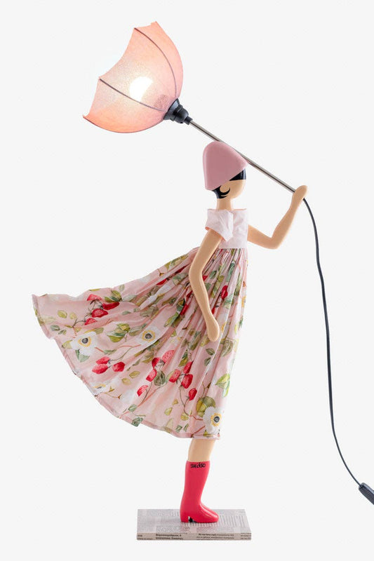 Decorative lamp shaped like a woman in a floral dress with a pink hat on a white background