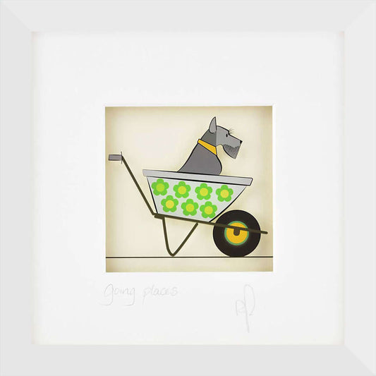 A framed image of a dog in a wheelbarrow