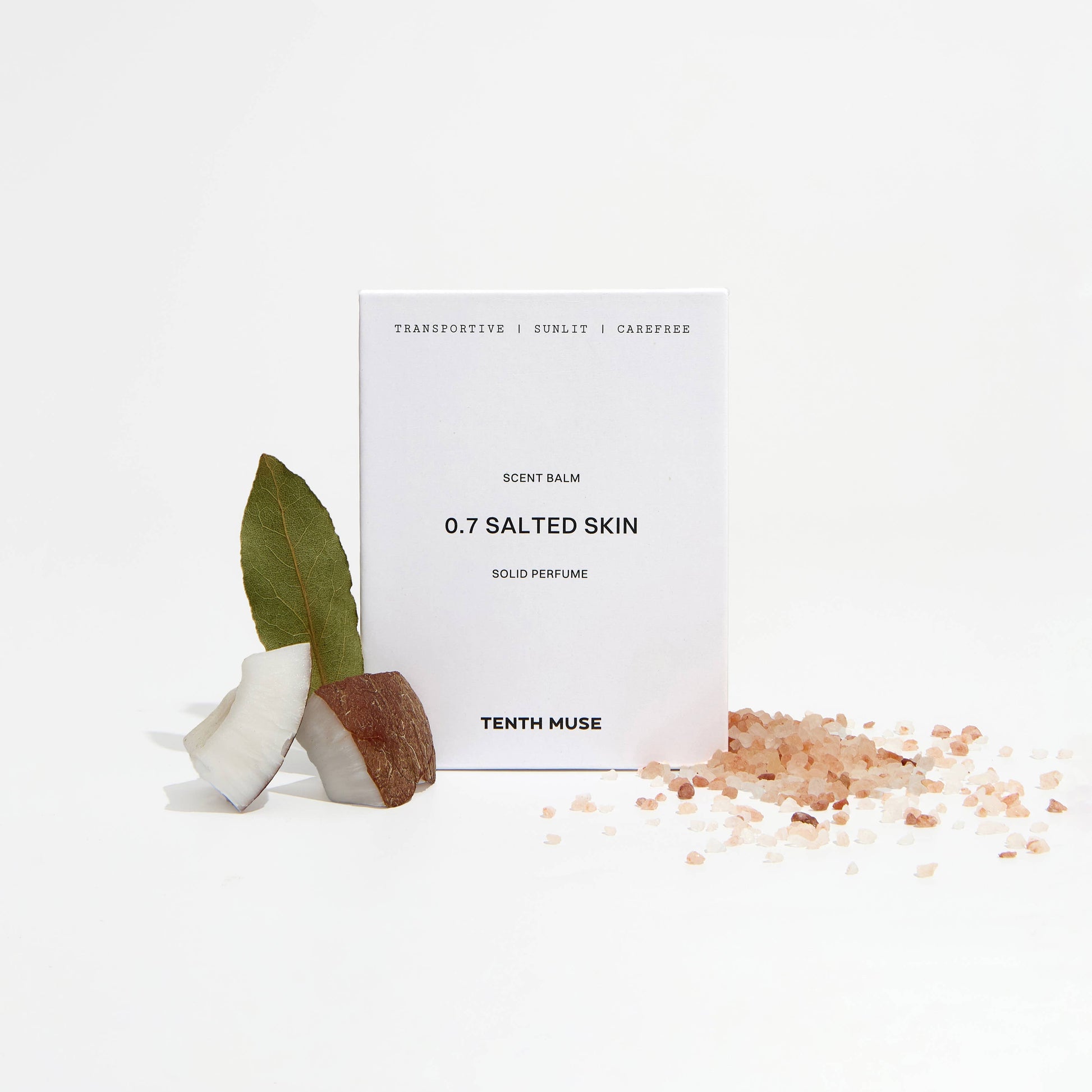 Perfume balm labeled '0.7 Salted Skin' by Tenth Muse with a small plant and salt crystals on a white background.