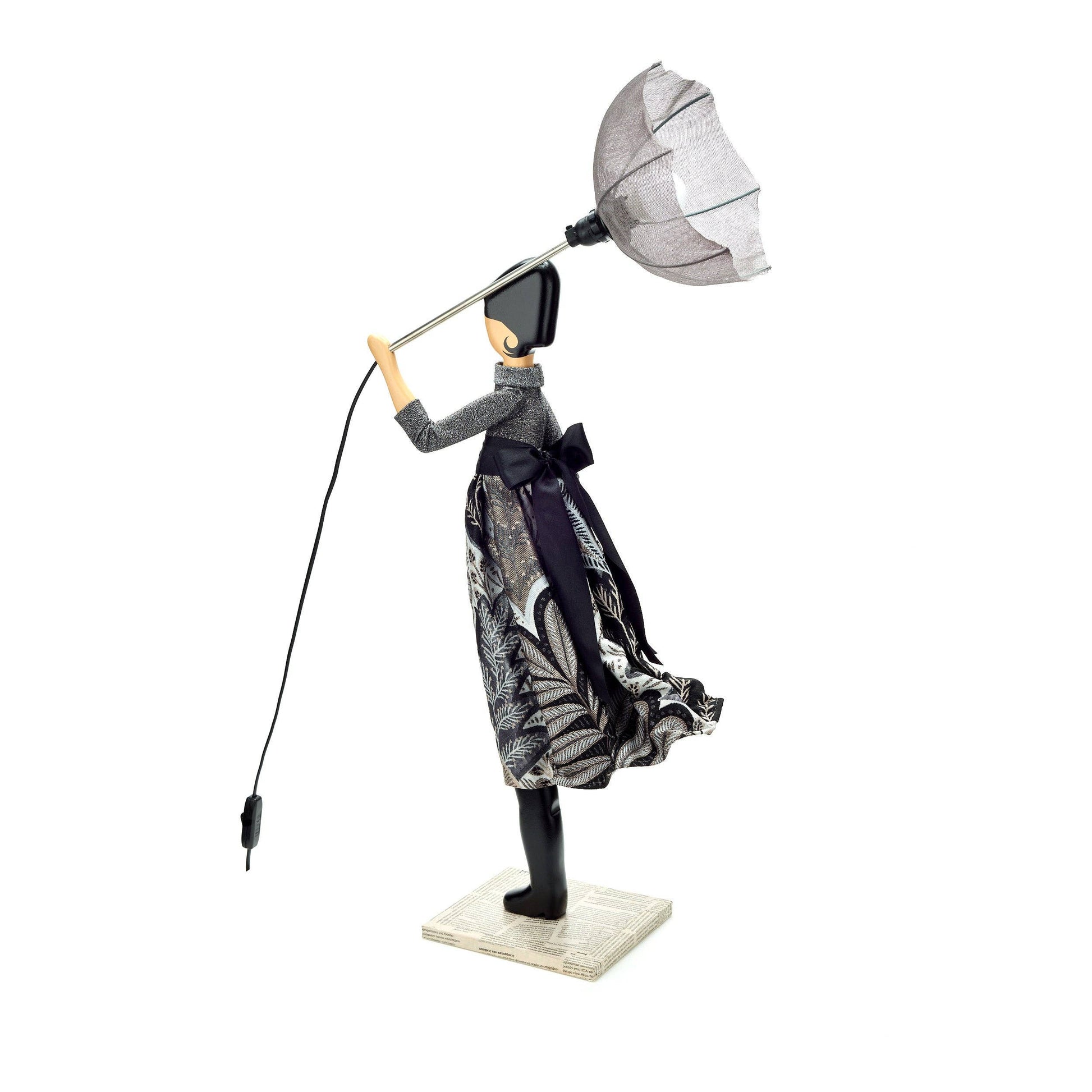 Decorative lamp with a person-shaped design holding a lampshade on a white background