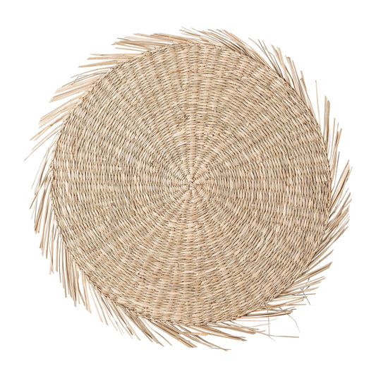 A round woven natural fiber placemat with a frayed, palm-leaf-like border, shown from a top-down view on a solid white background.
