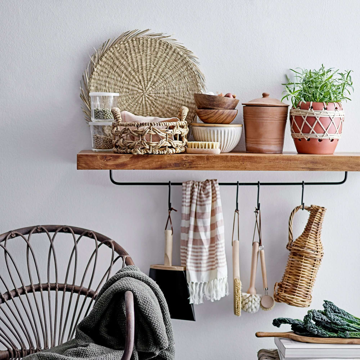 Nest living room with wooden shelf, wicker chair, and various home decor items.