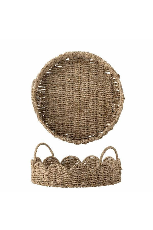 Woven seagrass basket with scalloped edge on a white background