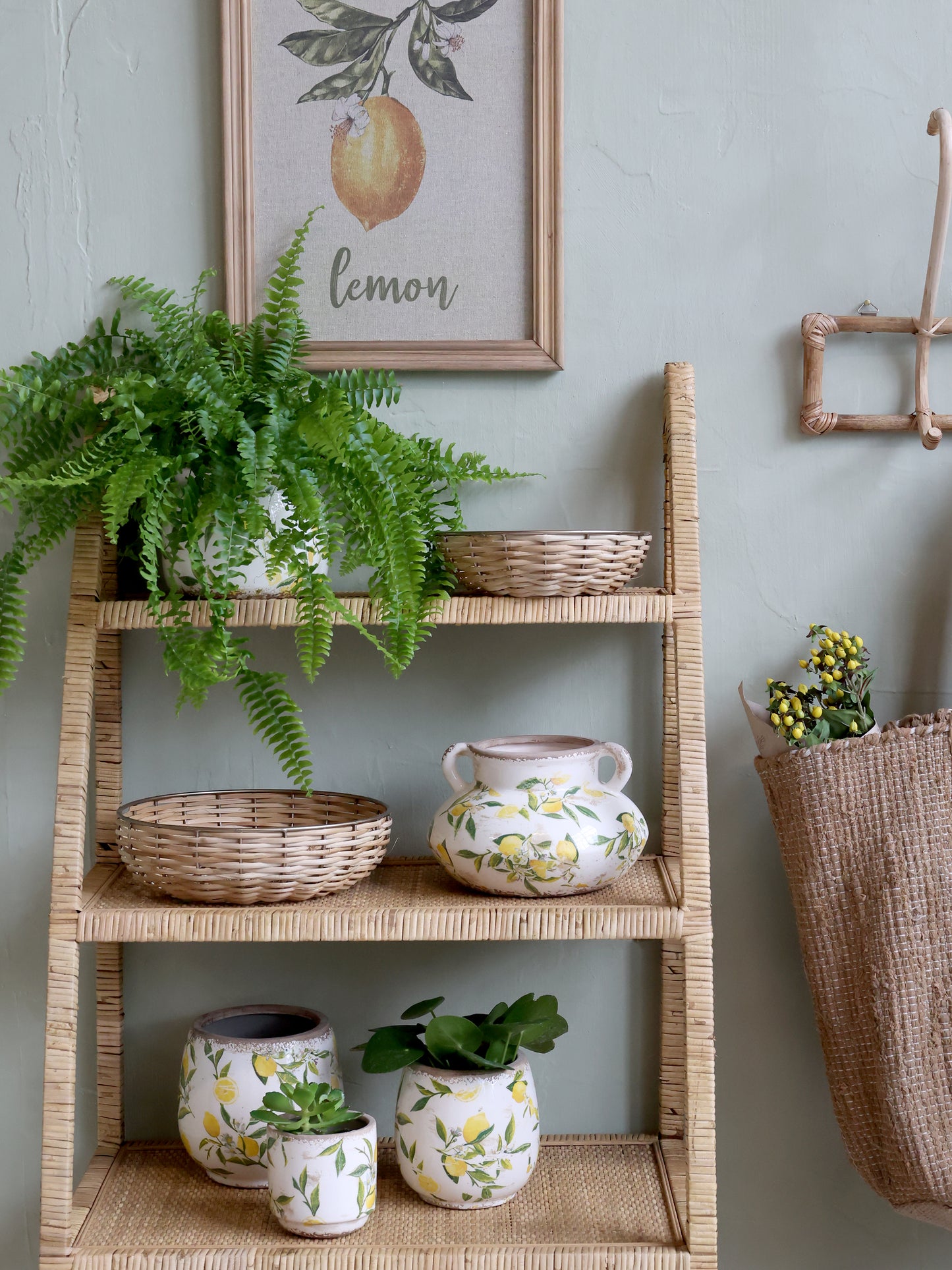 Wicker shelf with plants and decorative items against a light gray wall.