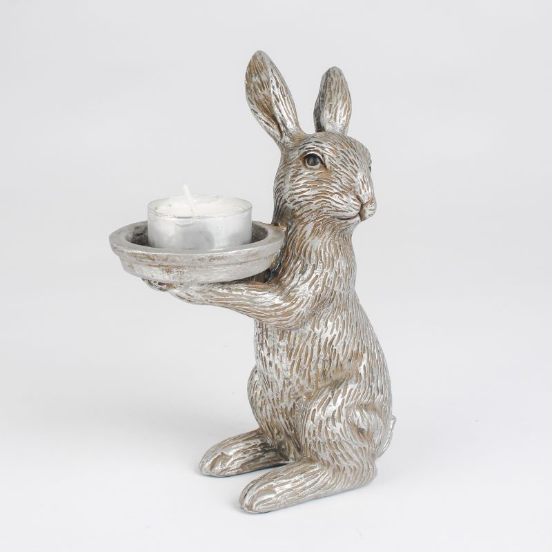 Decorative rabbit statue holding a candle on a white background