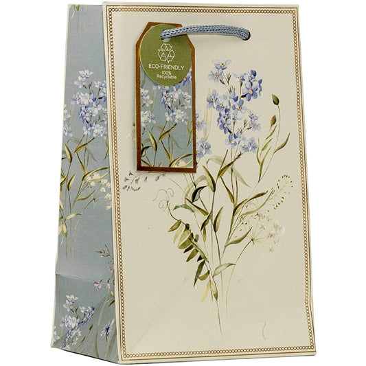 A decorative gift bag with a cream-colored front panel, blue and white floral illustrations, a blue rope handle, and a hanging green 'Eco-Friendly' tag.