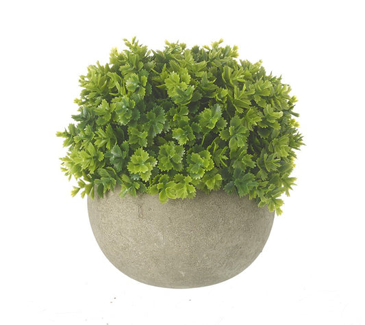 Green artificial topiary ball in a round stone-like pot on a white background