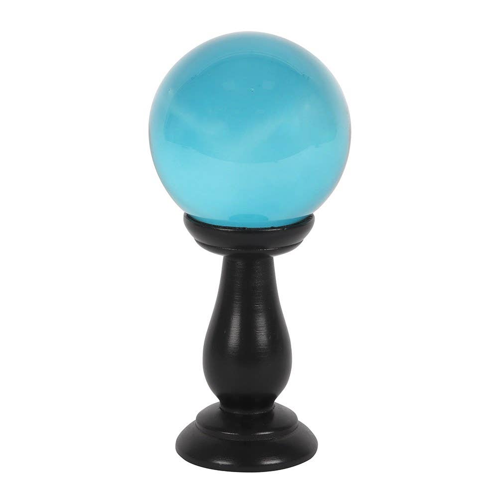 Turquoise crystal ball on a black stand against a white background