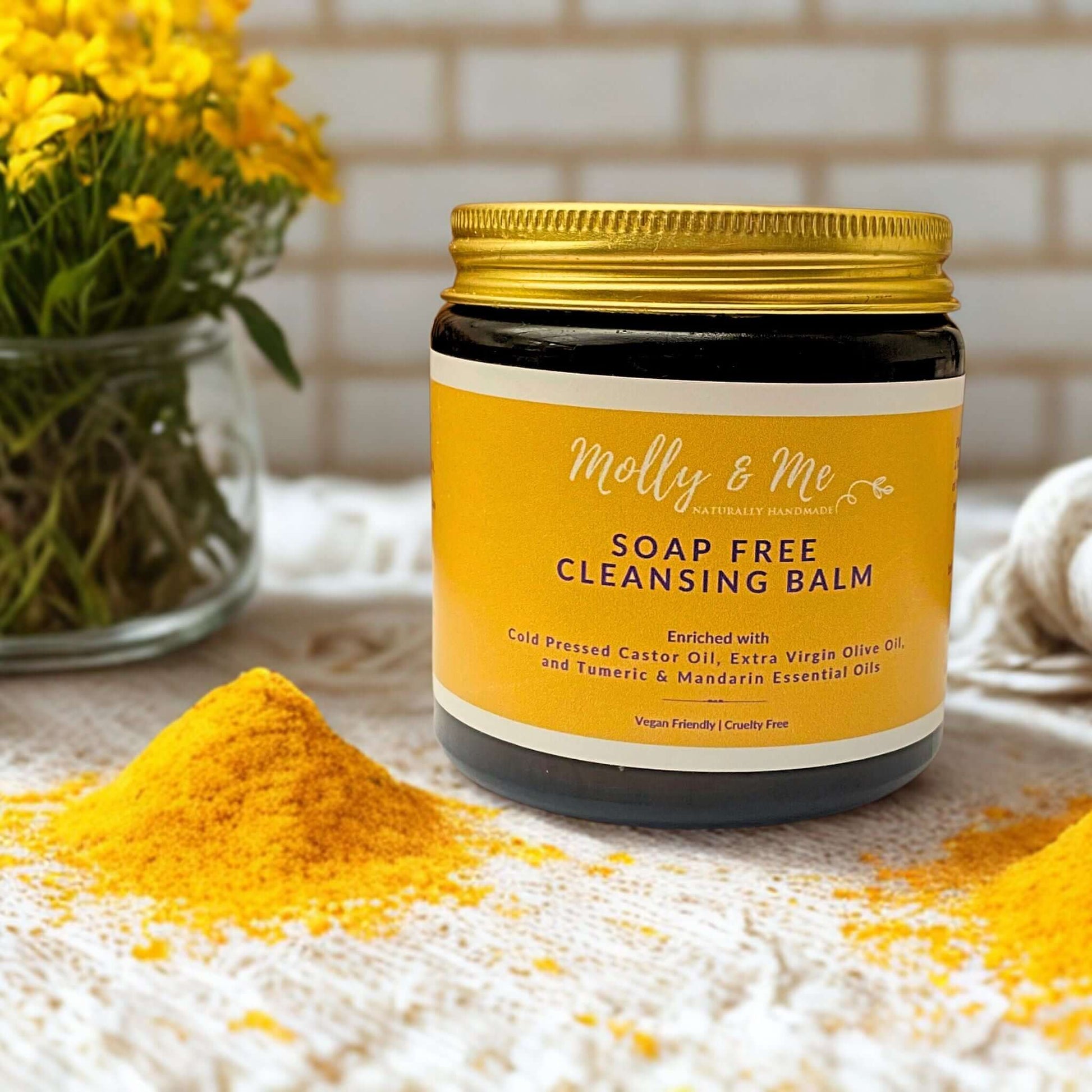Jar of soap-free cleansing balm with yellow powder and flowers in the background