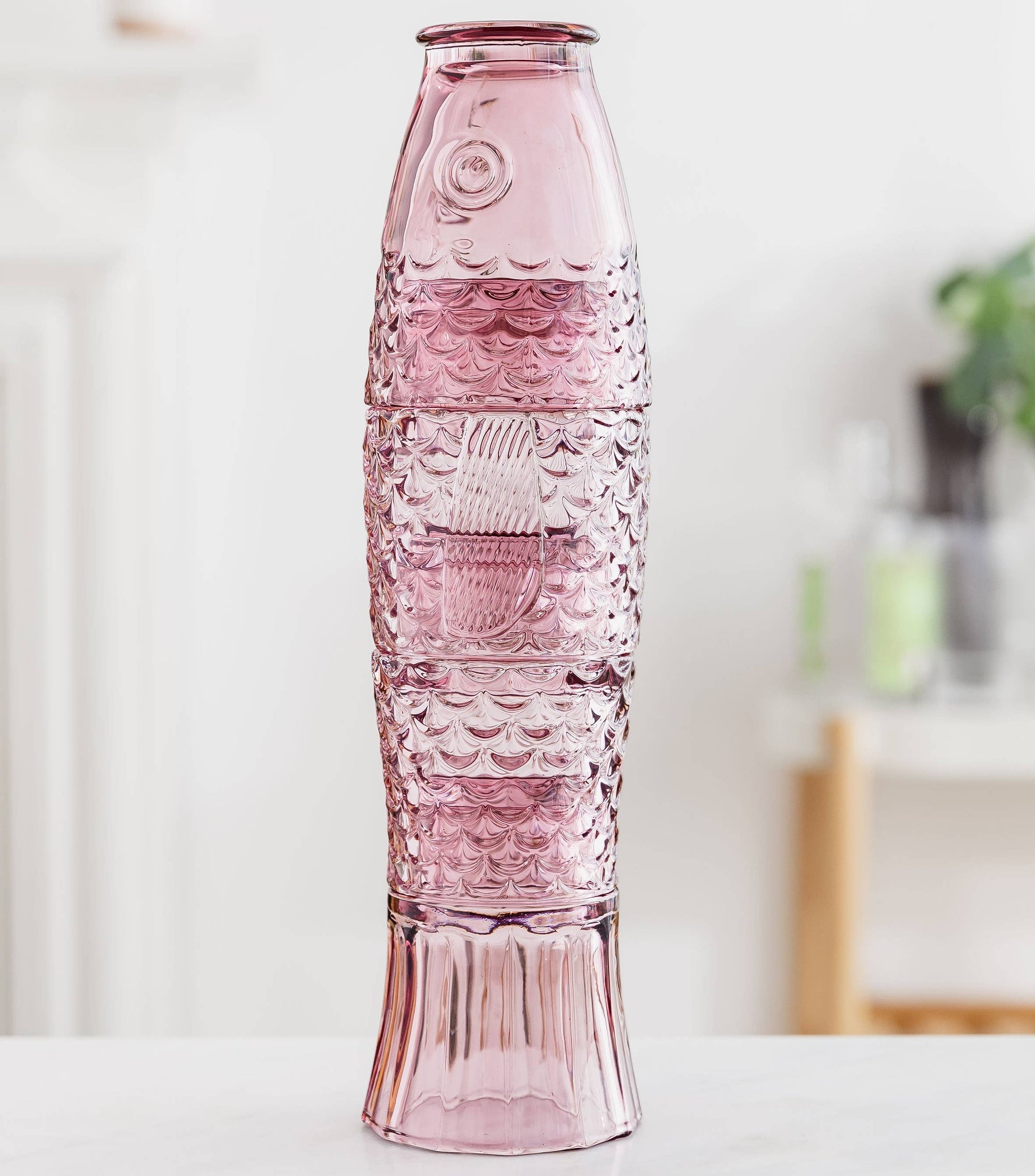 Pink textured glasses on a white surface with a blurred background
