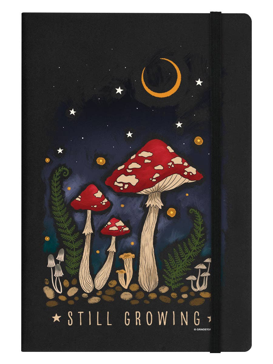 Notebook cover with mushroom illustration and 'Still Growing' text on a dark background