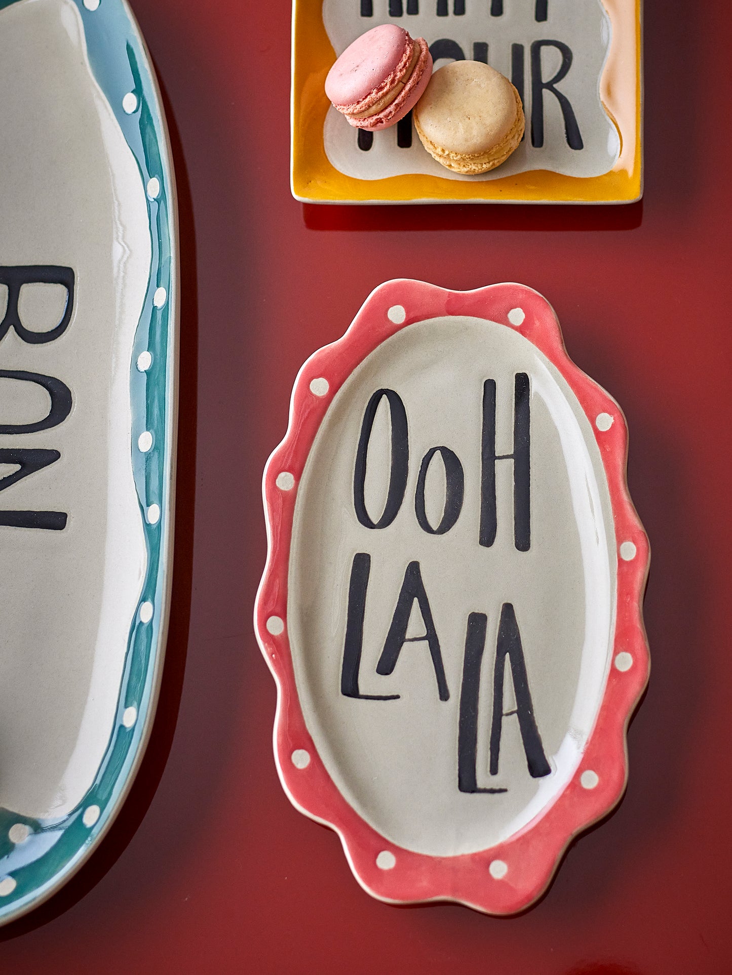 Decorative plates with text and polka dot designs on a red background