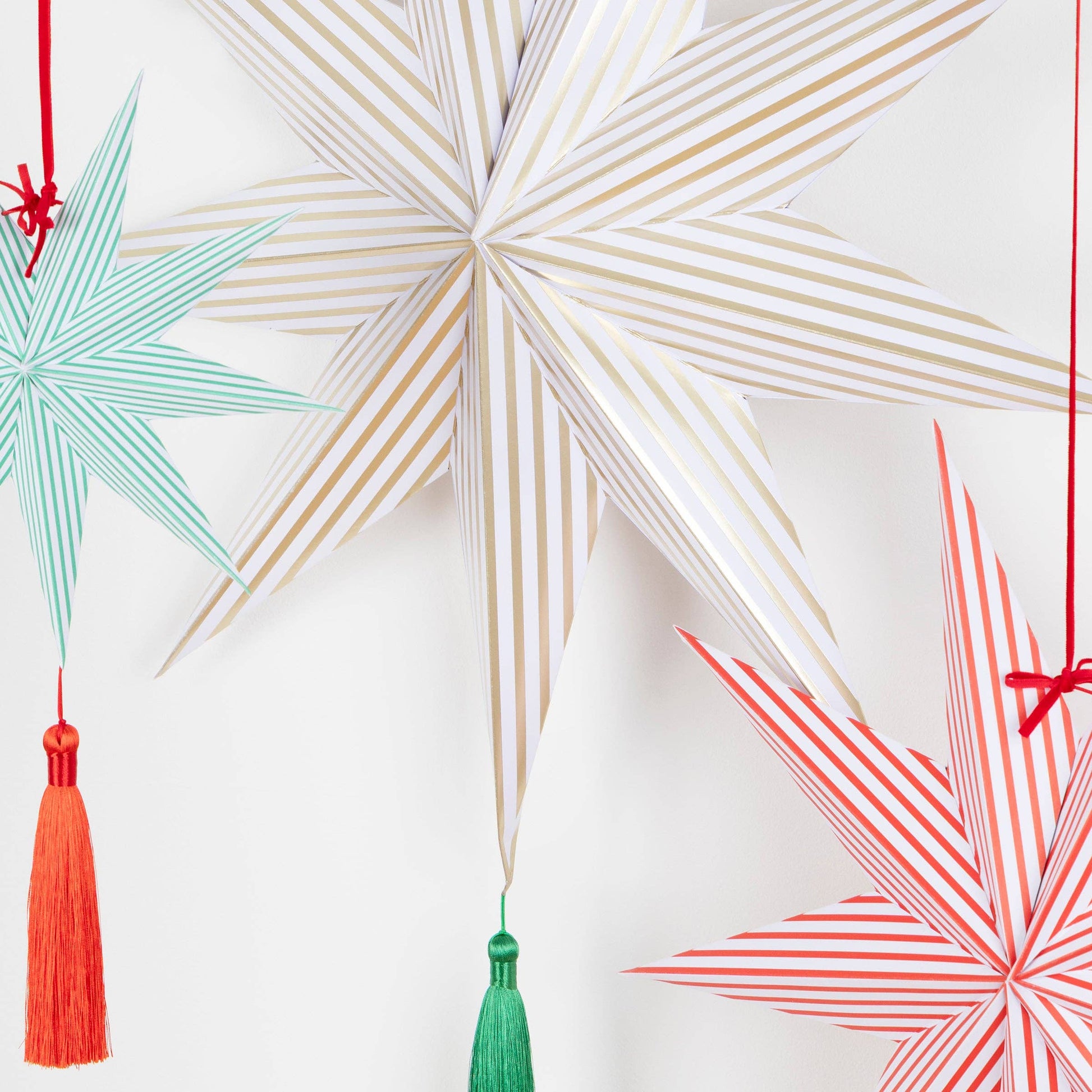 Decorative paper stars with tassels on a white background