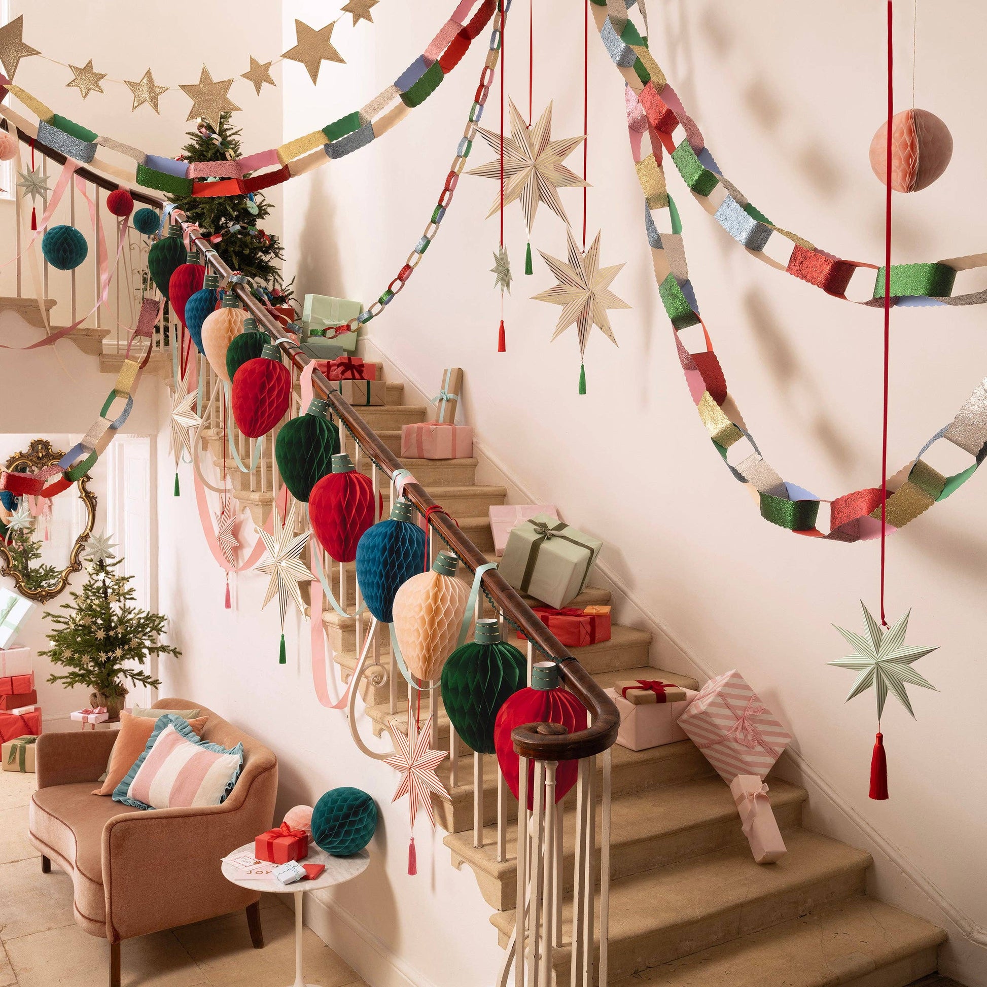 Decorative staircase with colorful garlands, stars, and gift boxes in a home setting.