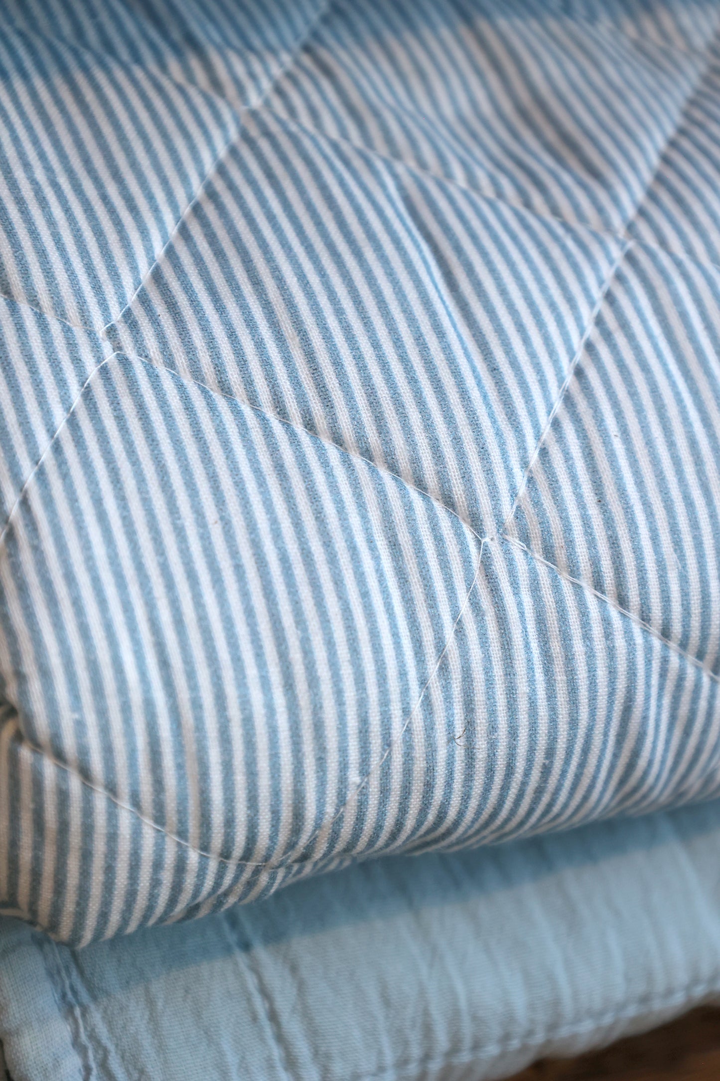 Close-up of a quilt with blue and white striped pattern