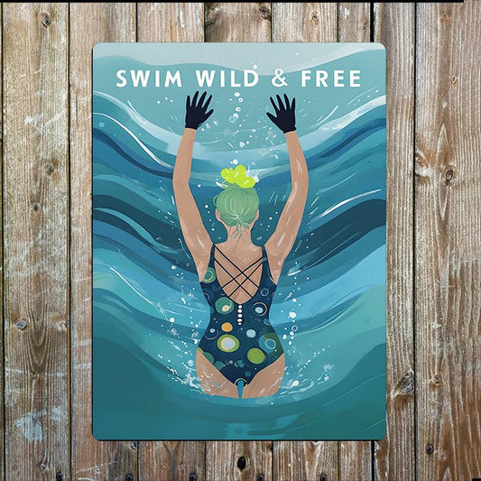 Poster with a swimmer underwater and 'Swim Wild & Free' text on a wooden background